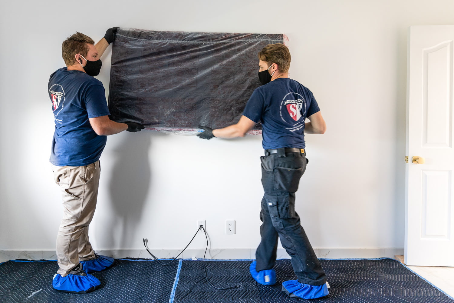 Two SoundVision technicians mounting a 4K TV on the wall