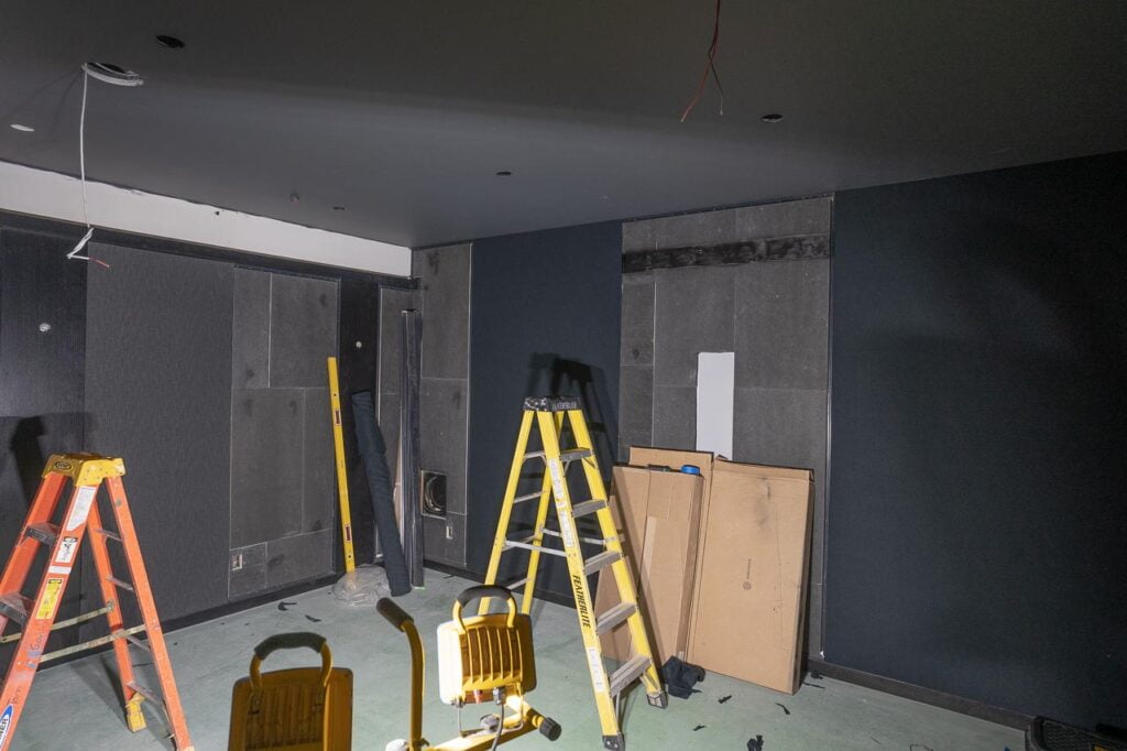 The construction site of a movie theater with some speakers and acoustical treatment in place.
